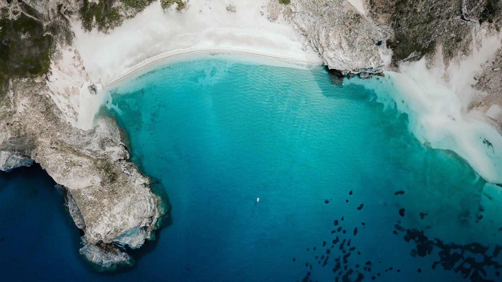 Türkise Bucht mit weißem Sandstrand, senkrecht von oben