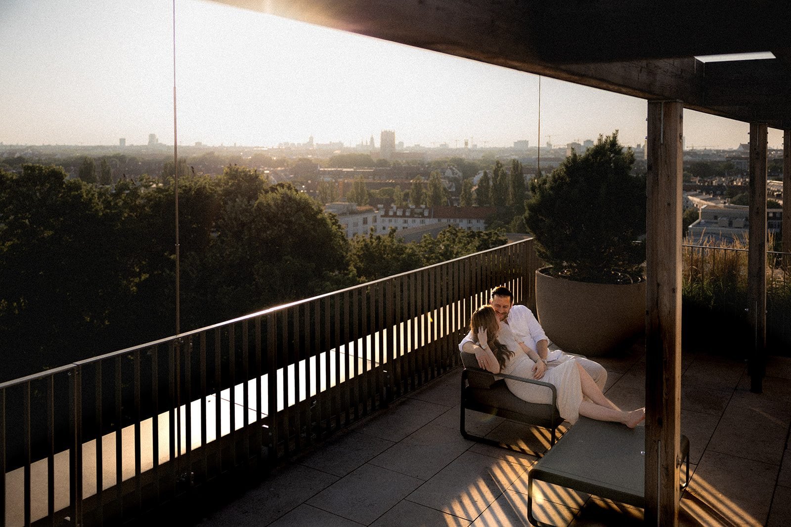 Paar auf der Dachterrasse im Sonnenuntergang über München